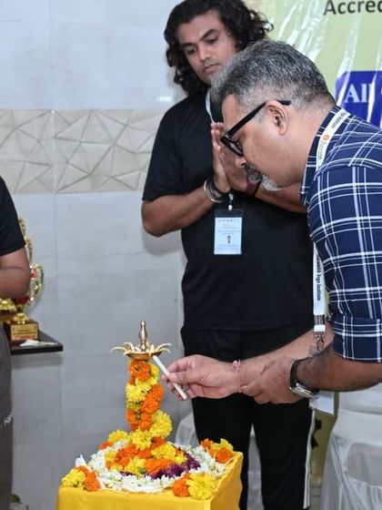 A judge participates in the ceremonial lamp lighting, marking the auspicious beginning of the competition.