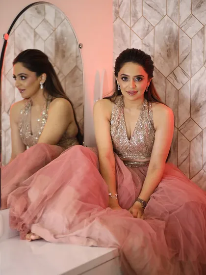 The full look, a beautiful pink tulle skirt paired with a sequined top. The soft glam makeup is the perfect finishing touch.