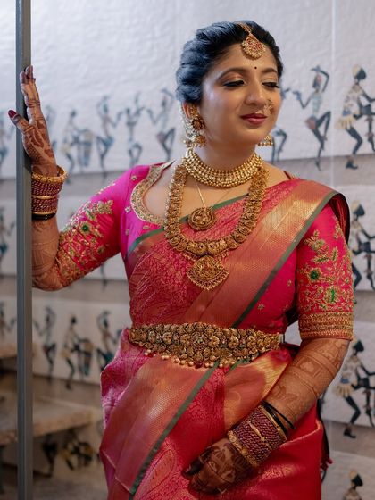 A full-length portrait of the bride, looking absolutely regal in her traditional attire and full bridal mehendi.
