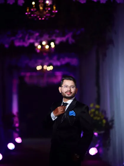 A confident groom at his reception. The blue pocket square adds a pop of color to his dark suit.