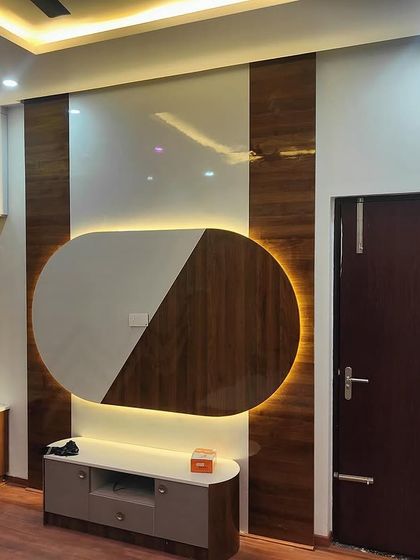 A bedroom in a recently handed-over home, featuring a custom TV unit and wardrobe with unique backlighting and patterns.