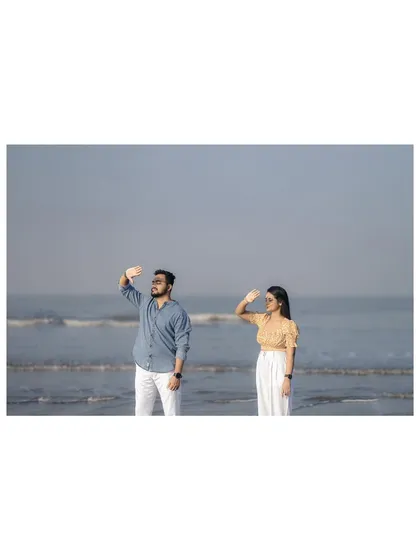 A fun and quirky pose by the ocean, showing the couple's playful personality.