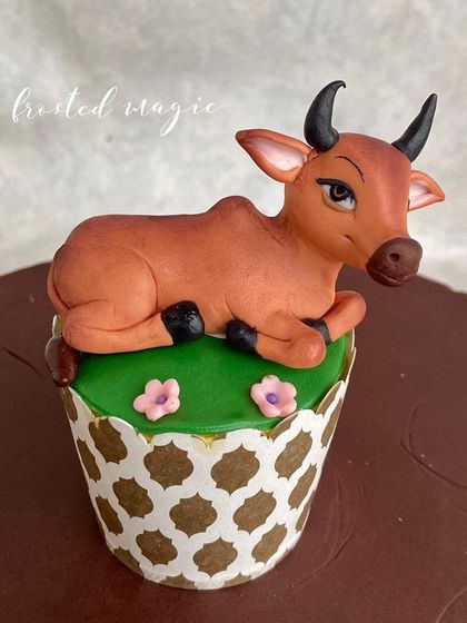 Another shot of the adorable cow, resting on a patch of edible grass.