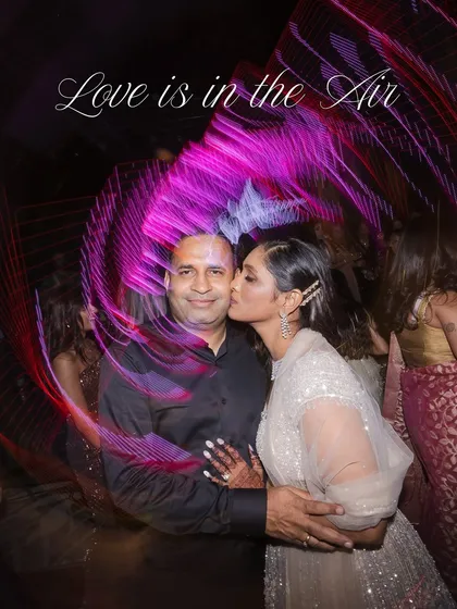 A candid moment of love and affection on the dance floor, captured with creative light trails that add to the energy of the photo.