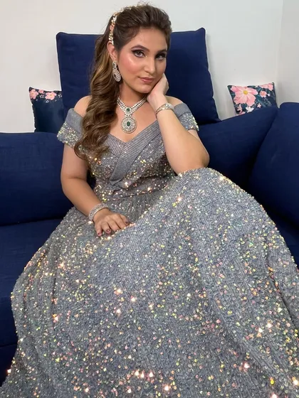The client seated in her glittering gown, with her hair styled in soft, glamorous waves. This hairstyle is perfect for complementing a heavily embellished outfit.