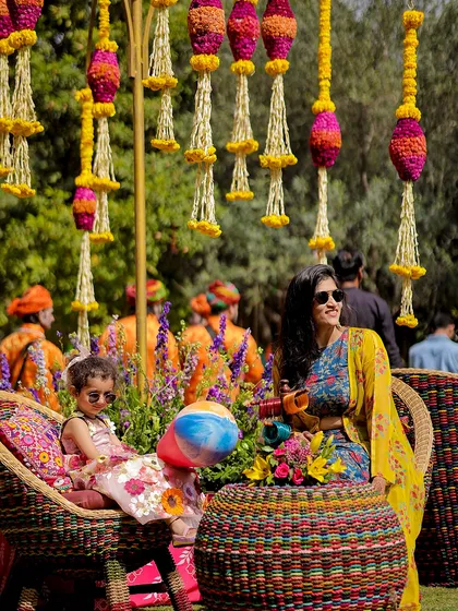 Guests enjoying the vibrant atmosphere of the Rajasthani carnival, seated in colorful woven chairs.