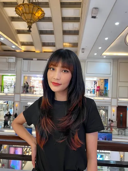 A wolf cut with colored ends. The pop of red at the tips adds an edgy, creative touch to this already trendy haircut.