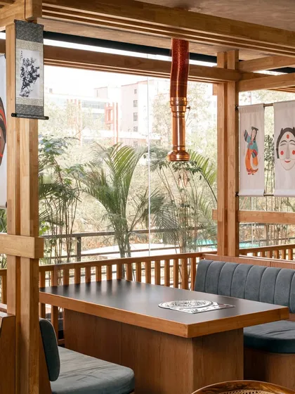 We incorporated traditional Korean art, like these hanging scrolls and masks, to infuse the space with cultural identity. These elements, set against the clean lines of the wooden booths, create a beautiful dialogue between heritage and modernity.