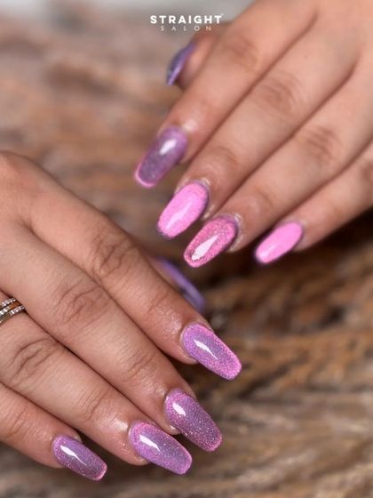 Another view of the sparkling pink and purple ombre nails. The glitter catches the light beautifully, creating a dazzling effect.
