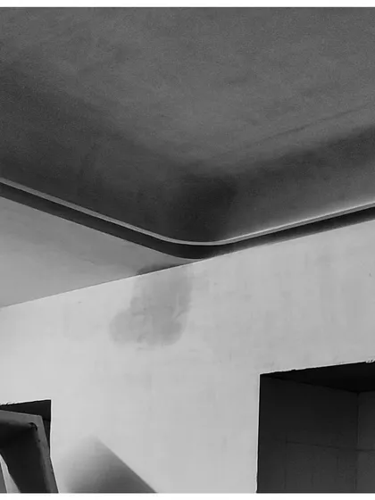 A work-in-progress shot of a curved ceiling detail. This minimalist gesture softens the corner of the room, creating a continuous, flowing surface that plays with light and shadow.