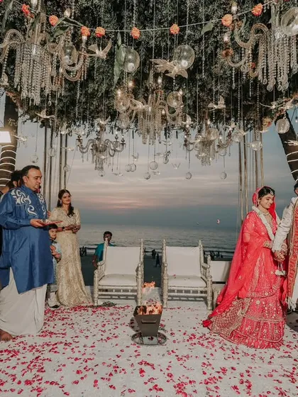 The pheras during a sunset beach wedding. The stunning ocean backdrop and the beautifully decorated mandap make this an unforgettable setting for their vows.