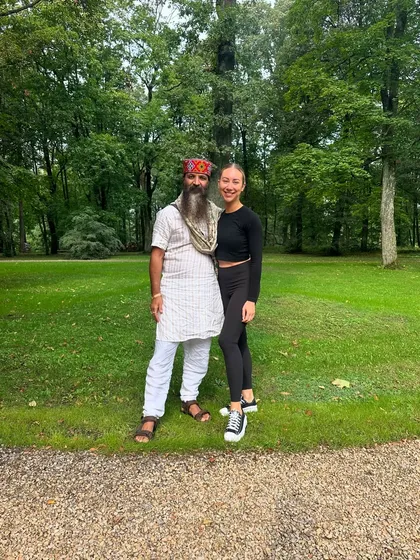 With a student in a park. My teaching is based on four principles: Duty is religion, love is God, service is worship, and truth is devotion.