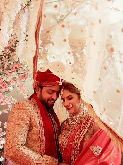 An intimate and romantic photograph of a couple under the bride's veil, surrounded by cherry blossoms. This soft and dreamy shot is a perfect representation of love and togetherness.