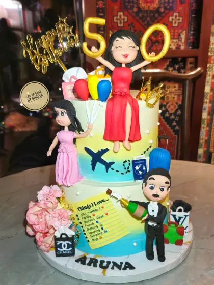 This two-tier cake tells the story of a fabulous 50th birthday. I worked closely with the family to include all her favorite things, from travel and shopping to her beloved family, represented by custom handmade figurines, creating a deeply personal and celebratory masterpiece.