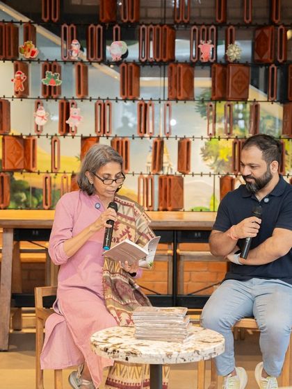 Author Mini Menon reads from her poetry book, "A Fly on The Wall," during her launch event, with our host listening intently.