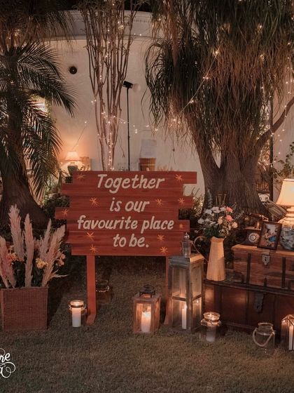 A personalized sign that reads 'Together is our favourite place to be' adds a heartfelt touch. I placed it within a rustic vignette of vintage chests, lanterns, and pampas grass.
