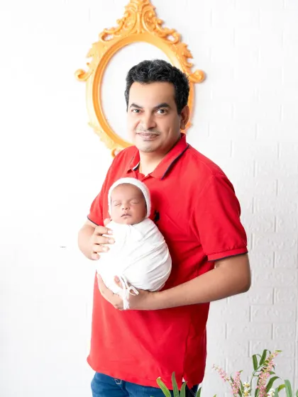 A proud father holds his swaddled newborn. This simple and sweet portrait highlights the special bond between a dad and his new baby, a memory to be cherished forever.