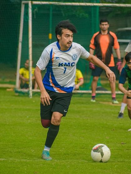 Dribbling with purpose, a player advances the ball up the field, looking to create a scoring opportunity.