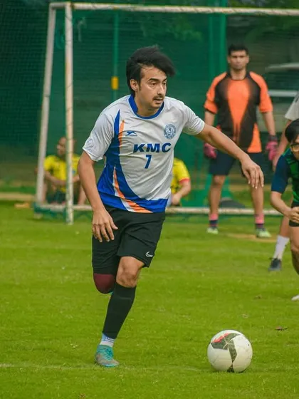 Dribbling with purpose, a player advances the ball up the field, looking to create a scoring opportunity.