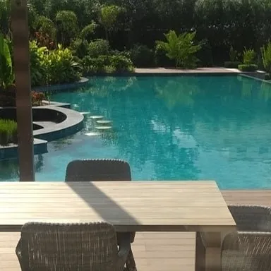 The view from the deck overlooking the custom-designed pool. We create holistic living environments where every element, from the house to the hardscaping, is part of a unified design.
