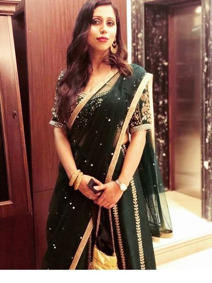 Our happy client looks radiant in a dark green saree-style gown by Pooja Peshoria. This shows how our pieces are perfect for attending weddings and other grand celebrations.