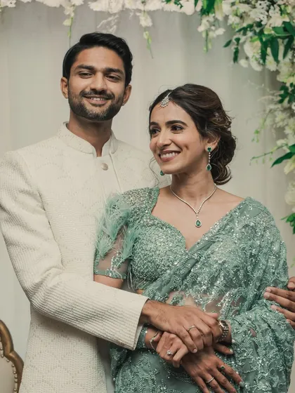 This couple's portrait showcases the complete look. The bride's elegant updo and soft makeup perfectly complement her sequined saree, creating a picture of modern grace.