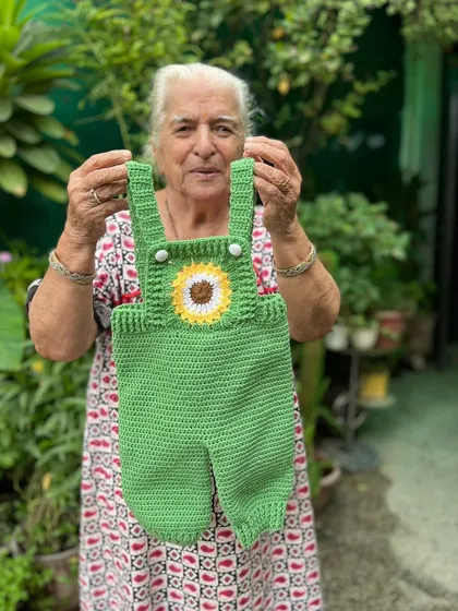 A sunny-day essential. This green crochet romper features a bright sunflower detail on the bib. It's a fun, comfortable, and unique piece for playtime adventures.