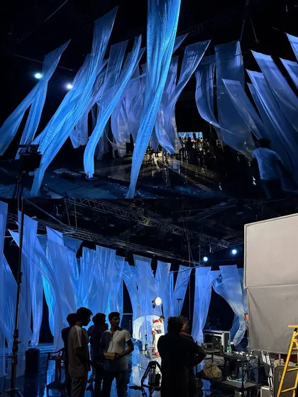 A wide, high-angle shot of the 'Bahli Sohni' set, showing the arrangement of the hanging fabric and the crew positioning lights and cameras.