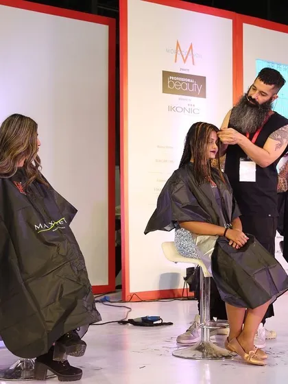 Focusing on the details during a live haircut on stage. Even with a large crowd watching, precision and technique are the most important things.