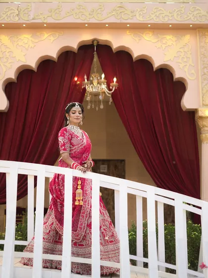 A beautiful portrait of the bride against a backdrop of red curtains and chandeliers.