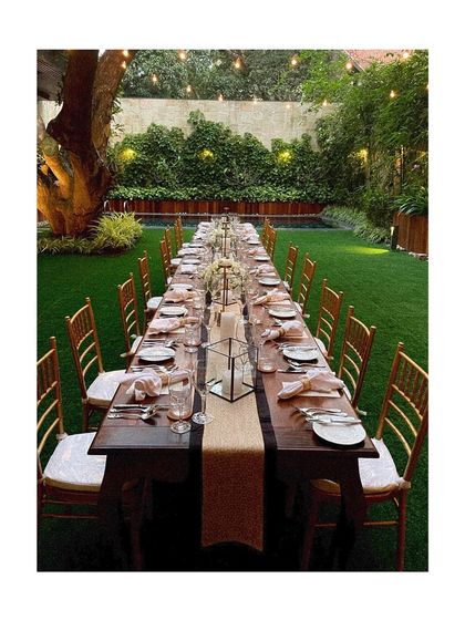 Another view of the outdoor garden party setup, showcasing the long communal table that encourages a friendly and relaxed atmosphere.
