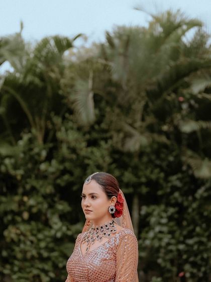 A half-face portrait of the bride, focusing on her intricate jewelry and calm expression.
