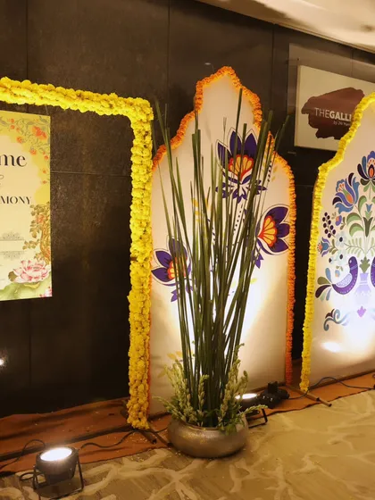 We blend tradition with modern design. This decor features backlit panels with traditional Indian motifs, framed by marigold garlands, adding a cultural touch to the entrance.