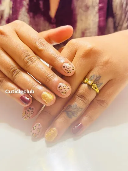 Show off your wild side with this chic animal print design on short, natural nails. I’ve combined a classic cheetah print with solid maroon and gold glitter accent nails for a look that is both trendy and sophisticated. This proves you don't need long nails to have fun with nail art.
