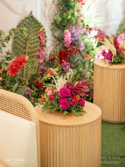 A detail shot of the entrance seating, focusing on the modern wooden table and the vibrant floral centerpiece that adds a pop of color.