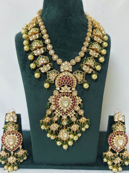 A heavy bridal set with a large, ornate pendant on the Rani Haar. This rental piece is perfect for making a grand entrance.