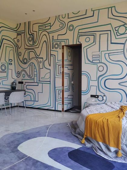 A full view of the bedroom, showing how the continuous line-art mural connects the sleeping area with the workspace, creating a unified and expansive feel.