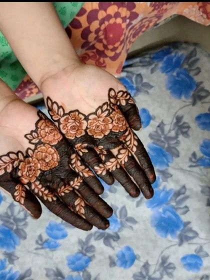 A close-up of the floral cuff design after the paste has been applied. The dark paste shows the crisp lines of the rose petals and leaves.