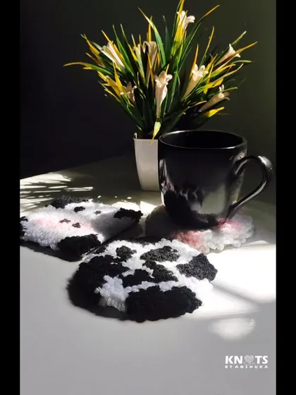 A set of cow pattern punch needle coasters on a table, ready for your morning coffee.