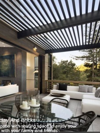 This spacious terrace patio is designed for entertaining. Featuring a large, comfortable seating area and a dining table under a modern slatted pergola, it seamlessly extends the living space outdoors with a view.
