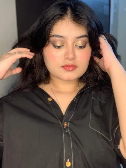 A simple, glowing makeup look with a touch of gold on the eyes.