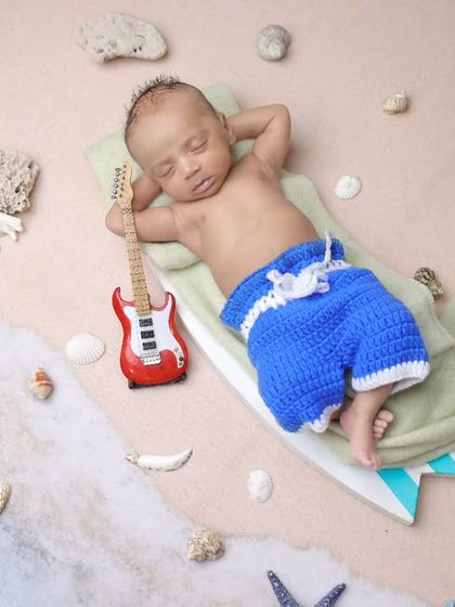 A creative twist on our beach theme, with the baby relaxing on a surfboard holding a tiny guitar. This overhead shot is playful and unique.