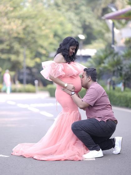 A truly heartwarming moment captured between expecting parents. The mom-to-be wears the peach mermaid gown, showcasing a tender pose perfect for any couple's maternity album.