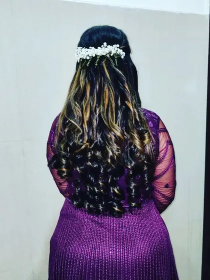 The back view of this hairstyle, showing off the beautiful curls and how they are complemented by a spray of baby's breath.