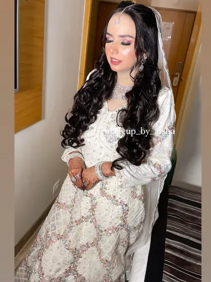 A full-length view of her beautiful white gown. The makeup and hair complete the ethereal look.