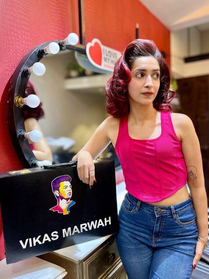 This client is rocking her new red hair with a retro-inspired wave. The color is a deep, rich red that complements her skin tone, and the styling gives it a touch of old-school Hollywood glamour.