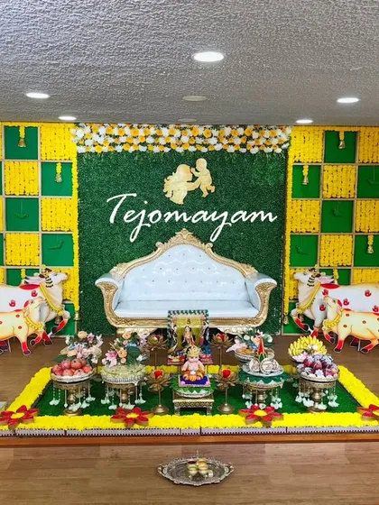 A baby shower setup with a Krishna theme, featuring cow cutouts and portraits of the deity. The plate decoration is minimal yet perfectly curated.