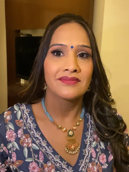 A close-up portrait of the guest's makeup. The soft smokey eye and bold lip create a balanced and beautiful look.