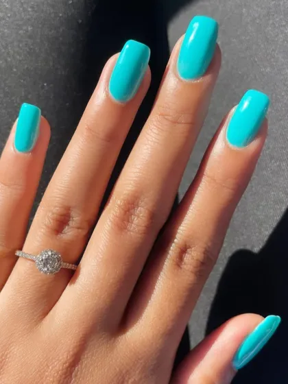 A beautiful, bright turquoise color on perfectly shaped square nails. A great pop of color for summer.
