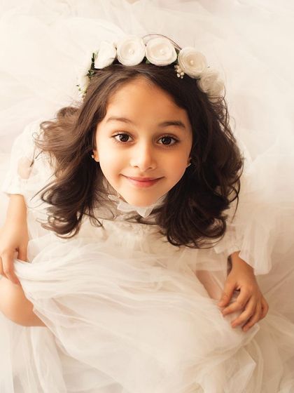 Looking up with a sweet and innocent smile. This high-angle shot is simple, beautiful, and full of light.